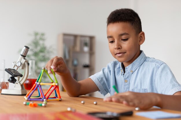 Niño aprendiendo más sobre química en clase.