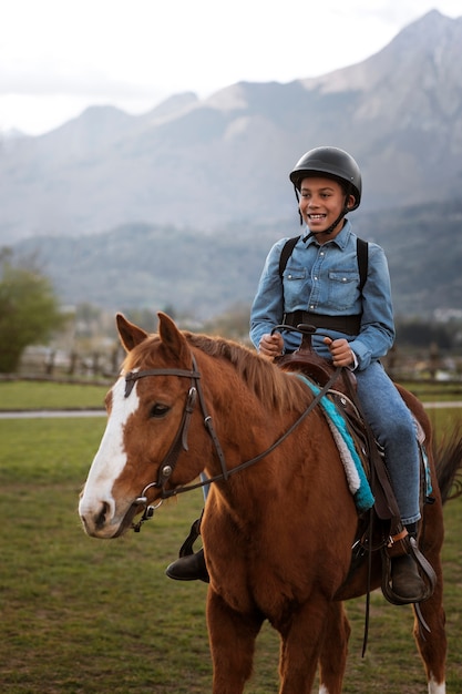 Niño aprendiendo a montar a caballo