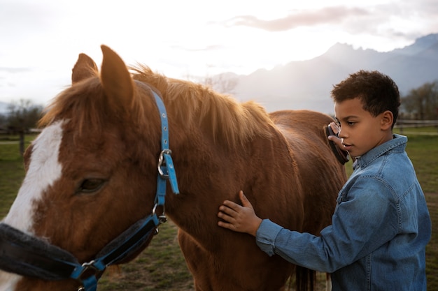 Foto gratuita niño aprendiendo a montar a caballo