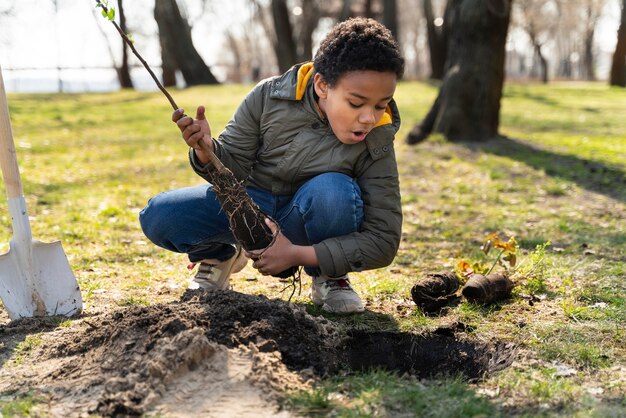 Niño aprendiendo a plantar un árbol