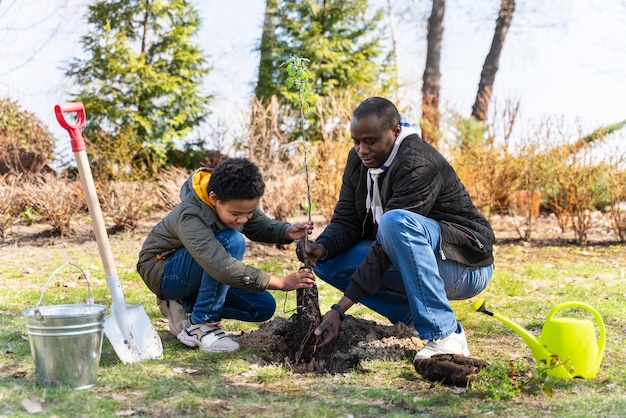 Niño aprendiendo a plantar un árbol