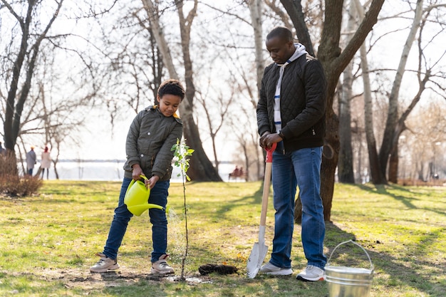 Niño aprendiendo a plantar un árbol