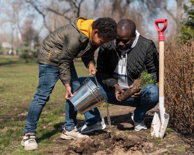 Niño aprendiendo a plantar un árbol.