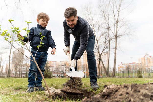 Niño aprendiendo a plantar un árbol.