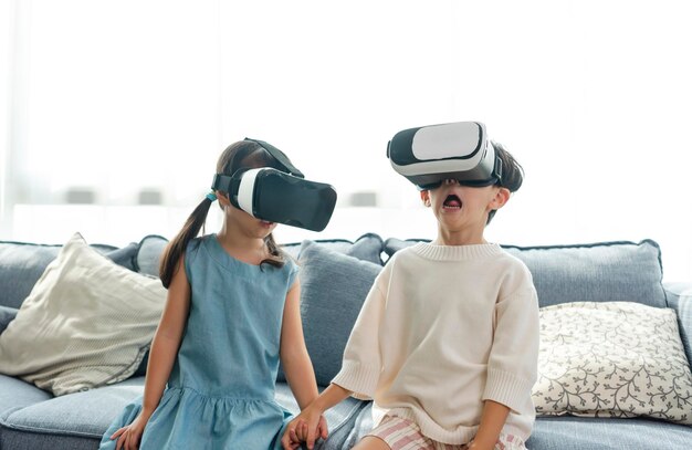 Niño asiático emocionado mientras usa auriculares 360 VR para metaverso de realidad virtual en casa