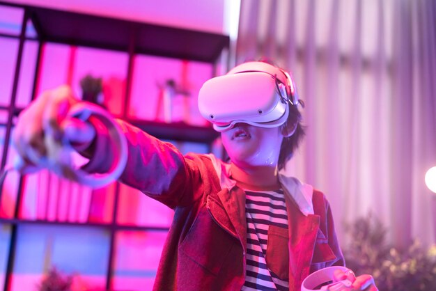 Niño asiático usa VR o gafas de realidad virtual parado y jugando un videojuego en la sala de estar frente a la televisión en casa en el período de cuarentena tecnología y concepto de innovación luz de neón