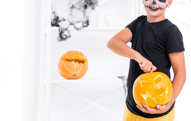 Niño aterrador con calabaza tallada para halloween