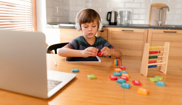 Niño con audífonos asistiendo a clases virtuales