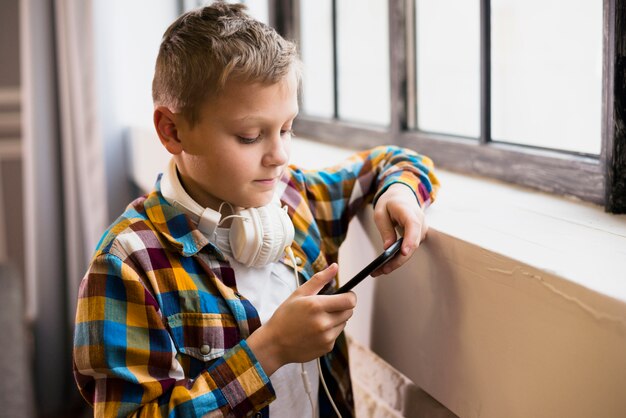 Niño con auriculares usando smartphone