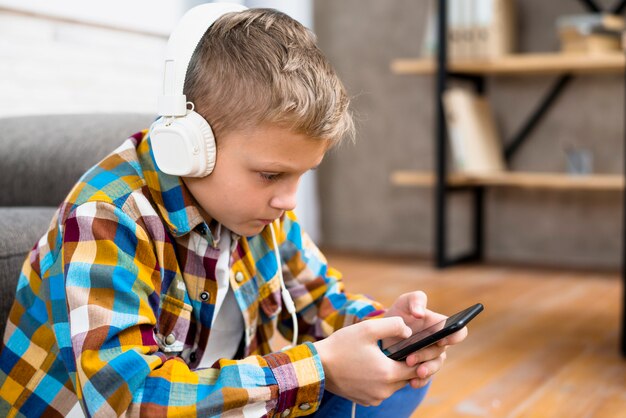 Niño con auriculares usando smartphone