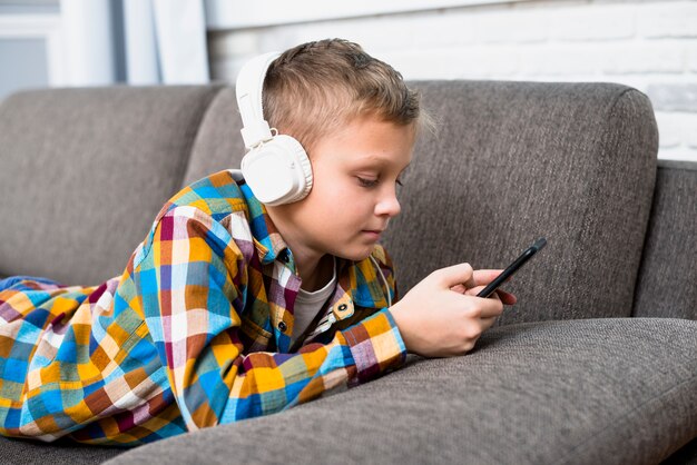 Niño con auriculares usando smartphone