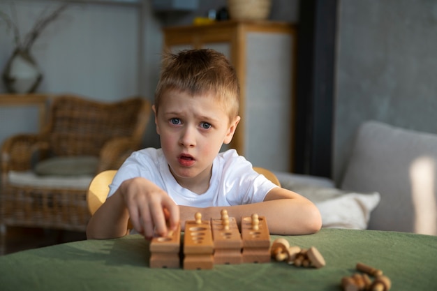 Niño autista joven jugando con juguetes en casa