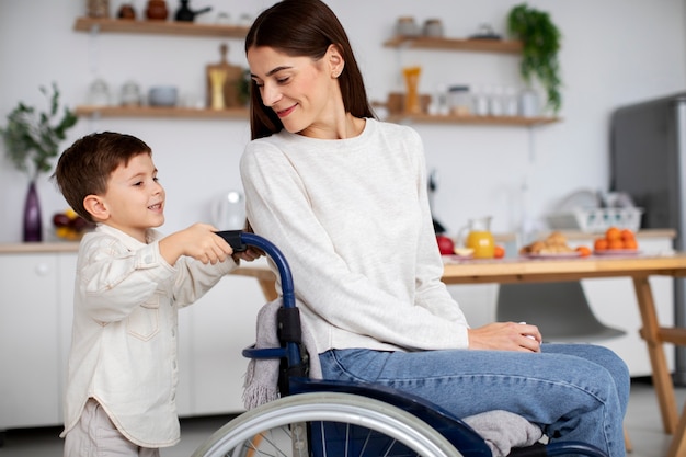 Foto gratuita niño ayudando a su madre discapacitada