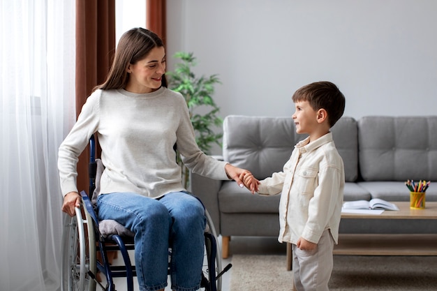 Foto gratuita niño ayudando a su madre discapacitada