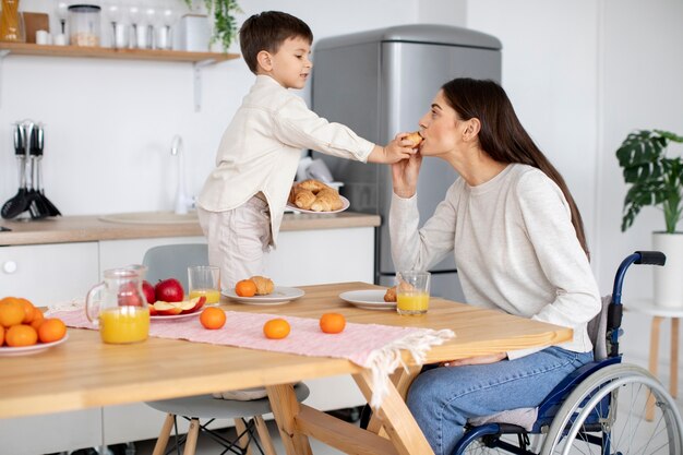 Foto gratuita niño ayudando a su madre discapacitada