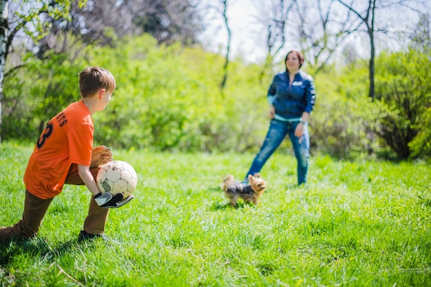 Foto gratuita niño con el balón en la mano y mirando a su madre