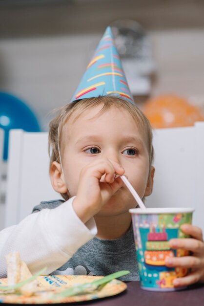 Niño bebiendo en la fiesta de cumpleaños