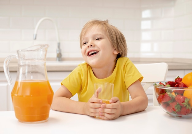 Niño bebiendo jugo en casa