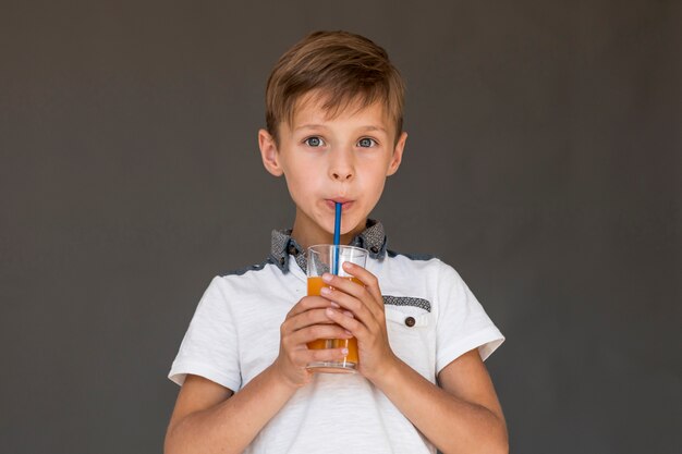 Niño bebiendo jugo de naranja