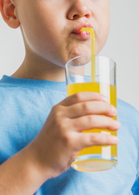 Niño bebiendo jugo con primer plano