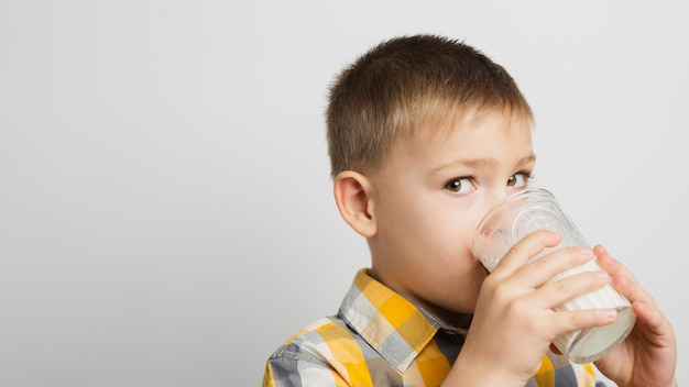 Niño bebiendo leche con vidrio