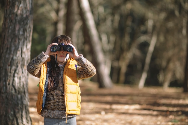 Niño con binoculares en el bosque