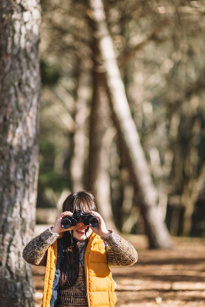 Niño con binoculares en el bosque