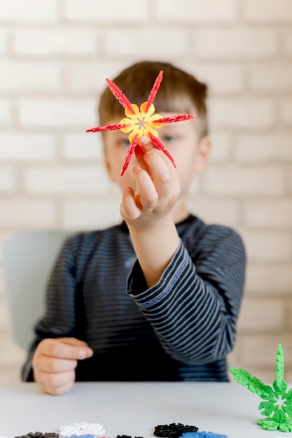 Foto gratuita niño borroso con juguete floral