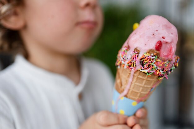 Niño borroso de vista lateral con cono de helado