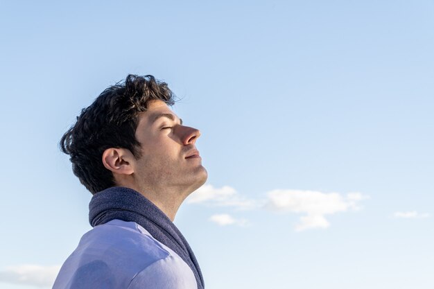 Niño con la cabeza hacia el cielo y los ojos cerrados en un día claro