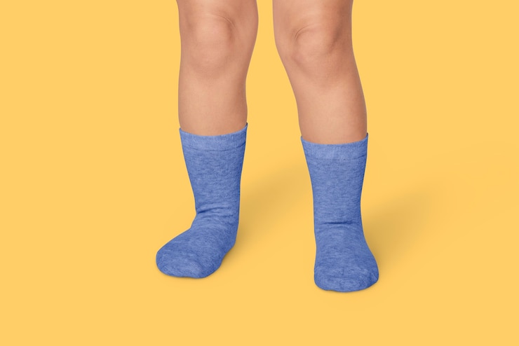 Foto gratuito niño con calcetines azules en estudio