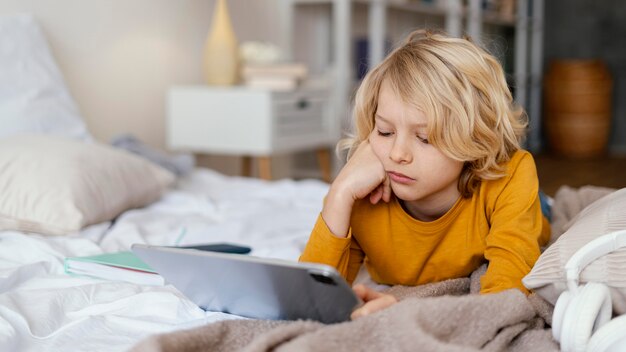 Niño en la cama con tableta