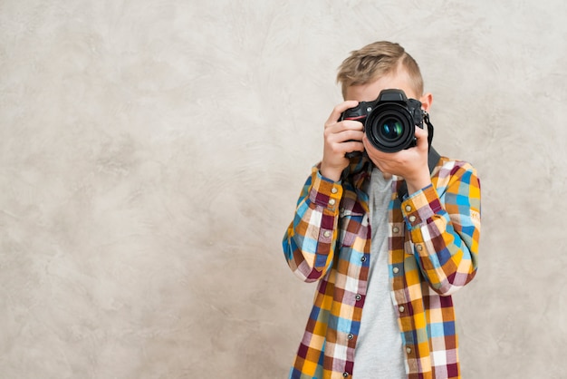 Foto gratuita niño con cámara