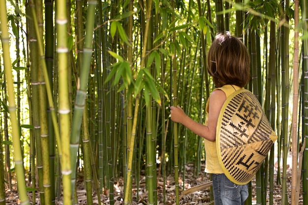 Foto gratuita niño caminando por un bosque de bambú