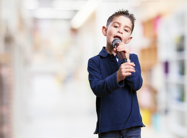 Foto gratuita niño cantando con fondo borroso