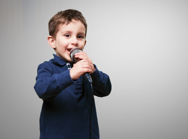 Niño cantando por un microfono