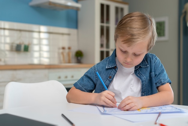 Niño en casa escribiendo y enfocando