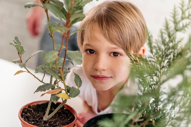 Niño en casa junto a plantas.