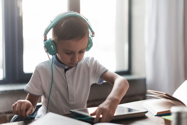 Foto gratuita niño con cascos y tablet