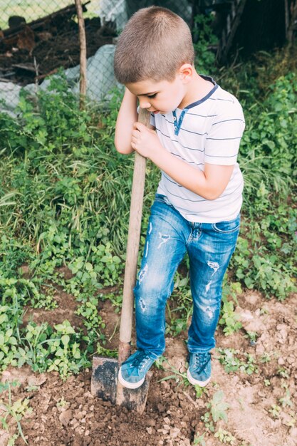 Niño cavando tierra en el jardín