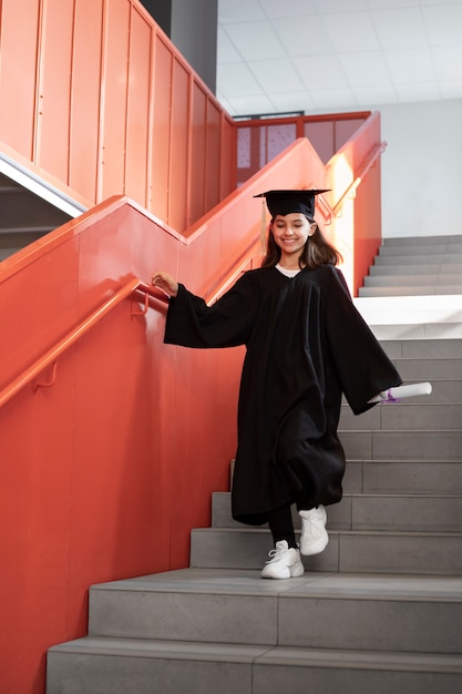 Foto gratuita niño celebrando la graduación de jardín de infantes