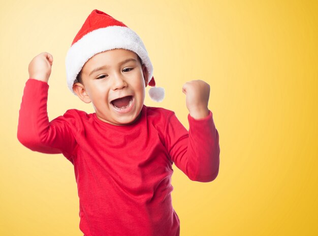 Niño celebrando su victoria con fondo naranja