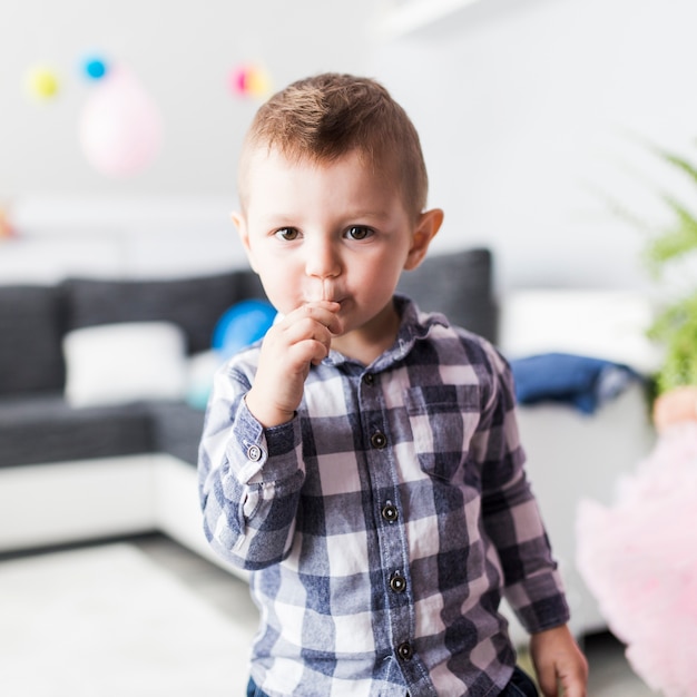 Niño chupando piruleta y mirando a cámara