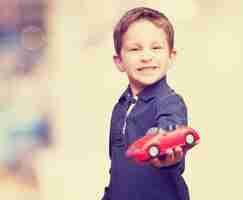 Foto gratuita niño con un coche de juguete