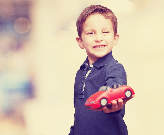 Niño con un coche de juguete