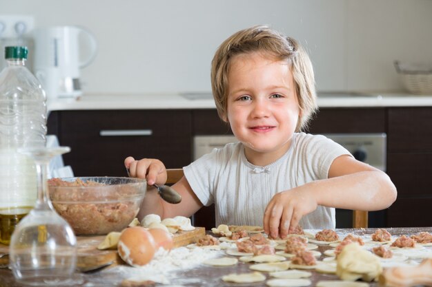 Niño cocinando albóndigas de carne