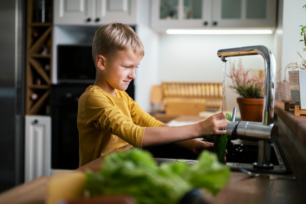 Foto gratuita niño cocinando y divirtiéndose en casa