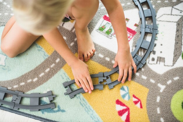 Niño colocando las vías de un tren