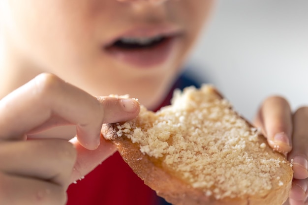 Foto gratuita un niño come pan con queso rallado.