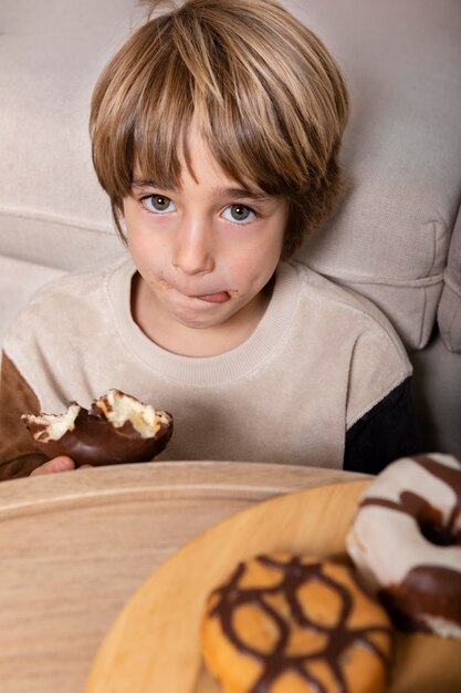 Niño comiendo donas en casa